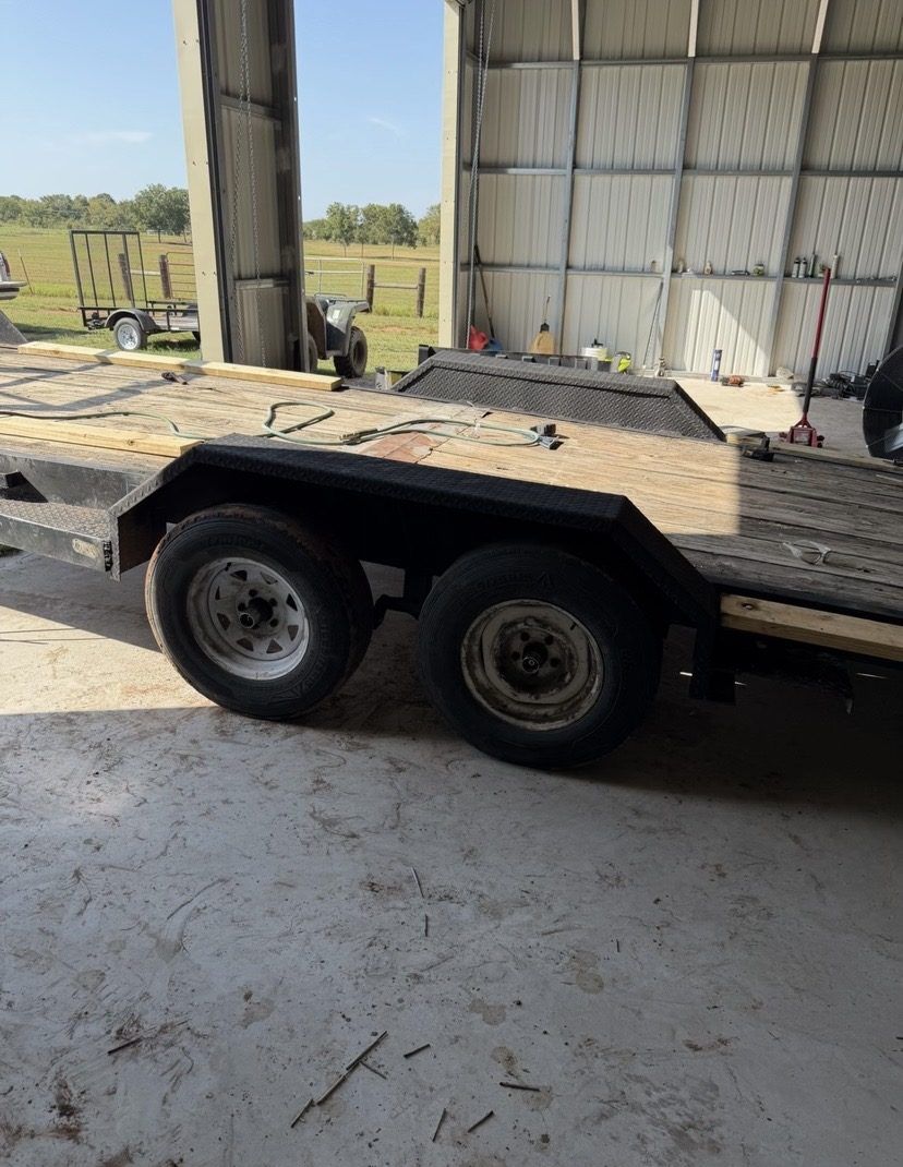 Drive over fender installed on a tandem axle car hauler trailer, side view inside a shop