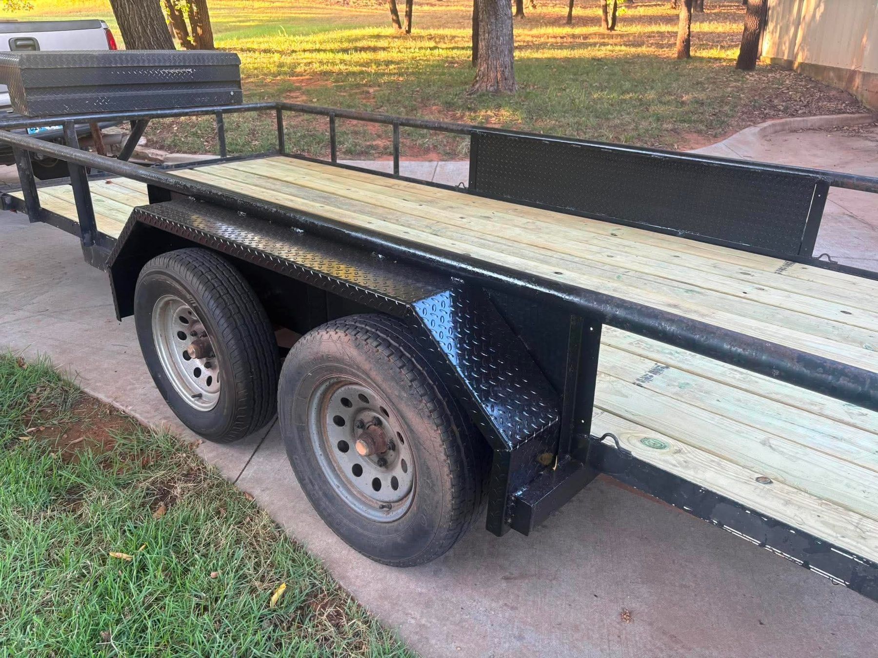 Heavy duty drive over trailer fender in 3/16 inch steel tread plate, 9 by 72 inches, mounted on a tandem axle utility trailer with a wood deck
